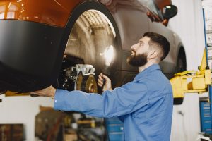 Man checking a car's brake pads near Indianapolis, IN