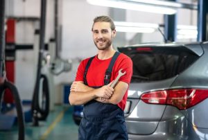 Mechanic standing near an SUV in a shop near Indianapolis, IN
