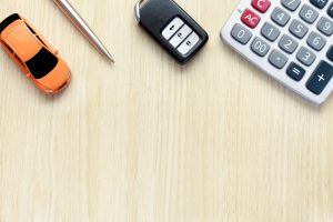 A table photographed from above with a toy car, a pen, a car key, and a calculator on it near Indianapolis, Indiana.