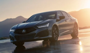 A dark grey 2024 Acura TLX driving in front of a sunset near Indianapolis, Indiana