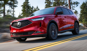 A red 2024 Acura MDX driving down a street near Indianapolis, Indiana