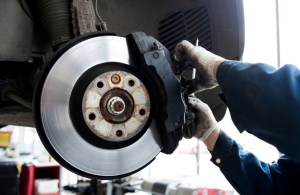 A car service technician servicing a set of brake pads near Indianapolis, Indiana