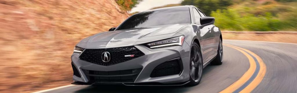 2025 Acura TLX in gray driving through winding roads near Indianapolis, IN, showcasing the luxury sedan’s sleek design, performance handling, and modern styling.