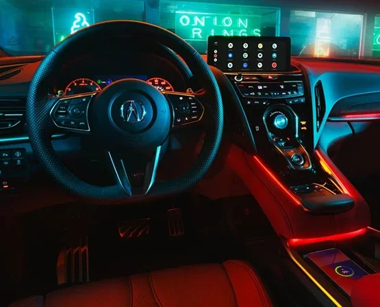 Acura RDX cabin at night, with the centre display and True Touchpad Interface lit by red ambient lighting